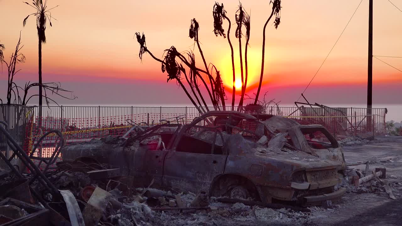 los coches quemados arden al atardecer junto a una casa en la ladera tras el incendio de thomas en 2017 en el condado de ventura, california