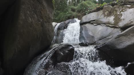 Vista-Panorámica-De-La-Cascada-Oreja-Del-Mundo,-Minca,-Colombia,-Enclavada-Entre-Exuberante-Vegetación-Y-Rocas.