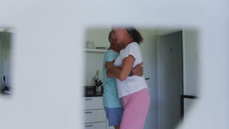 pareja de adultos mayores caucásicos bailando juntos en casa
