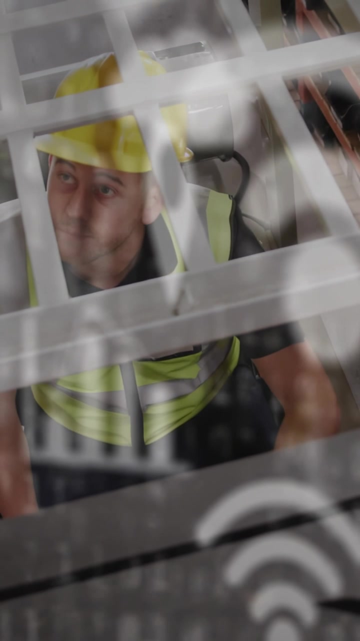 Operaio edile che ispeziona una griglia, con icone che si sovrappongono alla griglia, controllando gilet ed elmetto per la sicurezza.