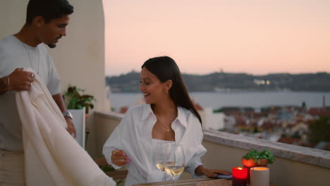 gentle man bringing blanket to wife at sunset balcony. romantic couple terrace