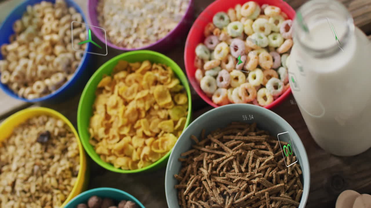 Colorful bowls with breakfast cereals and milk jug on kitchen table