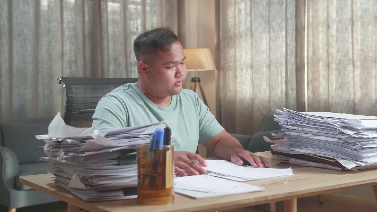 Fat Asian Man Being Tired Working Hard With Documents At The Office
