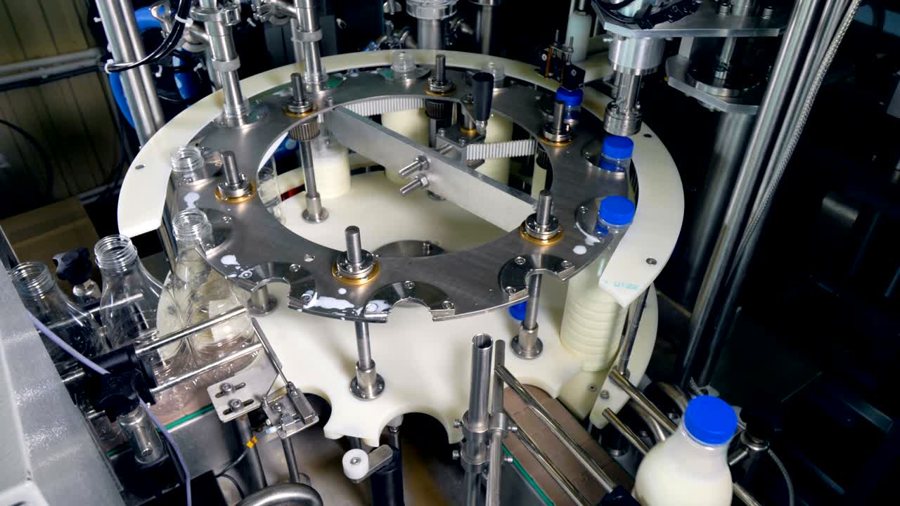 빈 병이 우유 채우기 기계에 들어갑니다.