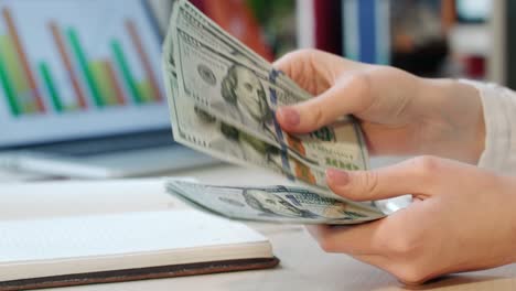 mujer contando dinero a mano en efectivo en la oficina. crédito en efectivo en dólares.