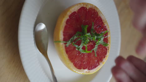 Streuen-Sie-Fein-Gehackte-Pfefferminze-über-Eine-Grapefruit