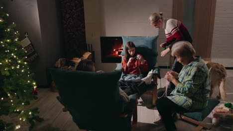 familie, die an weihnachten zusammen am kamin strickt