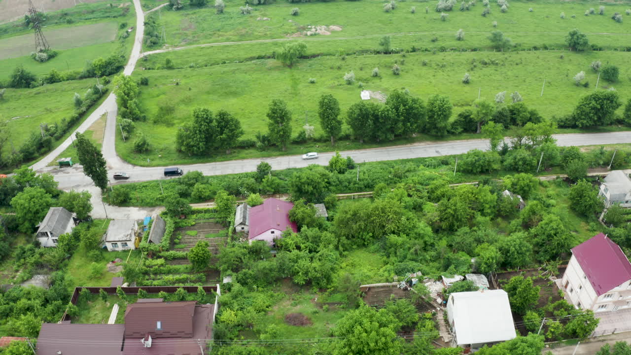 Aerial View of a Rural Landscape with Green Fields, Roads, and Houses