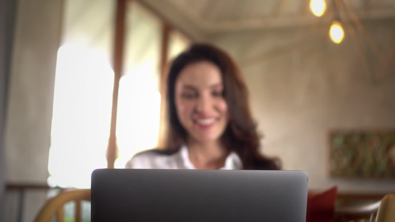 mujer feliz ejecutiva sonriendo mientras trabaja desde casa usando su computadora portátil
