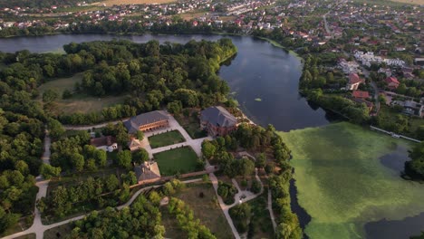 mogoșoaia palace by lake at sunset, lush greenery surrounding historical architecture, aerial view