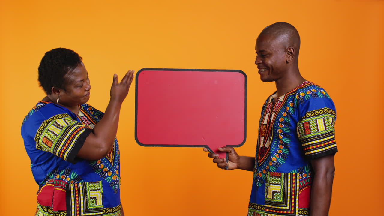 Ethnic young couple presenting speech bubble board