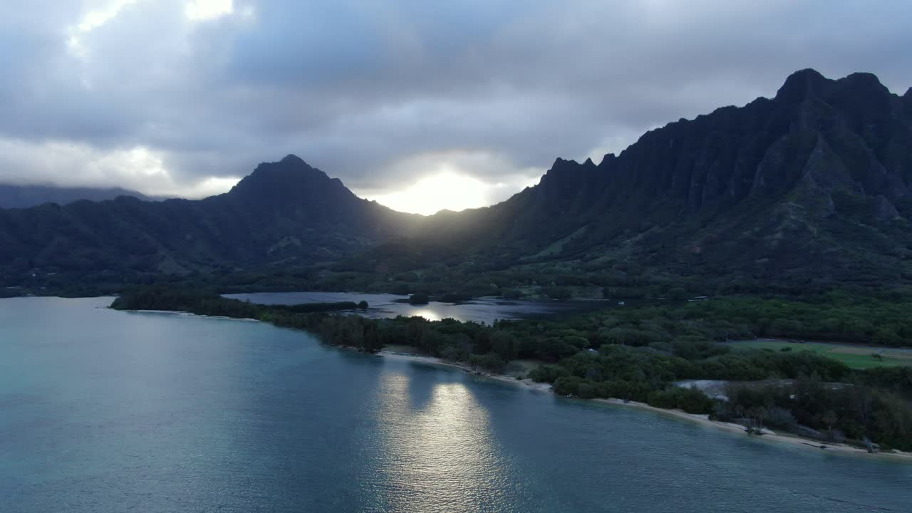 배경에 넓은 산맥이 있는 잔잔한 바다 물고기 연못 위의 정적인 공중 촬영