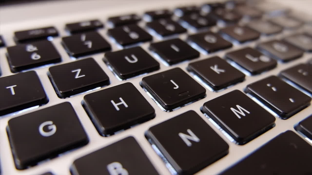 Close up of a black laptop keyboard in daylight