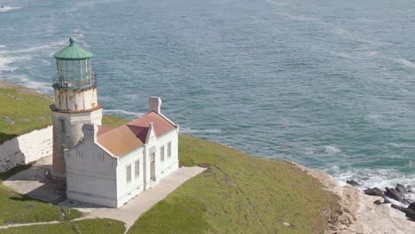 historic lighthouse on california coast, pull back to reveal cliffs