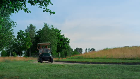 carrito de golf conduciendo por el fairway afuera. jugadores de golf explorando el campo en un día soleado