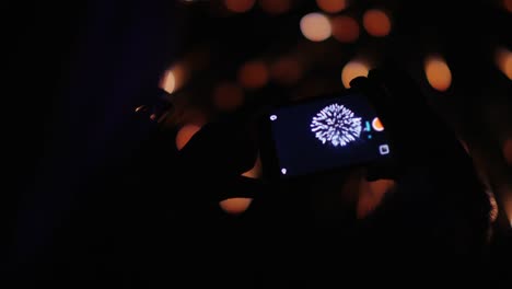 a woman admires the fireworks in the night sky. take pictures with your smartphone. 4k 10 bit video