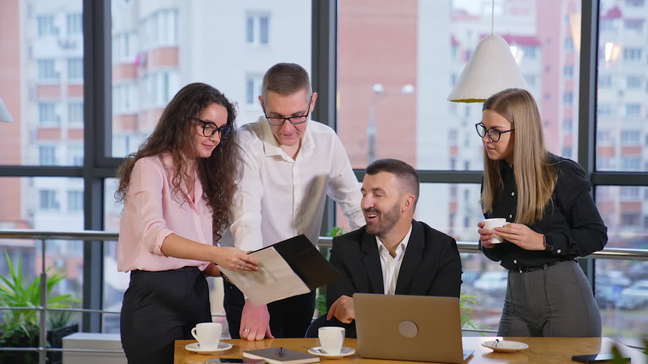 Business team of colleagues having discussion in office. Female employee shows her co-workers a document and people comment it.
