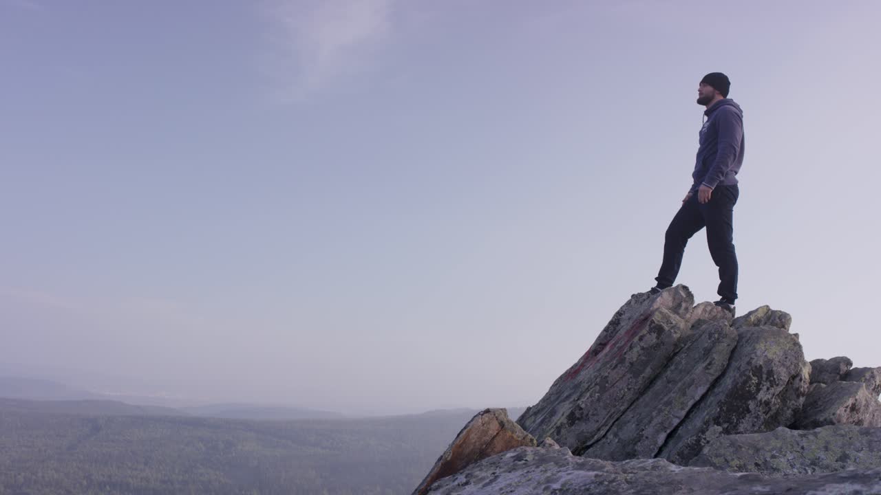 hombre de pie en el pico de la montaña