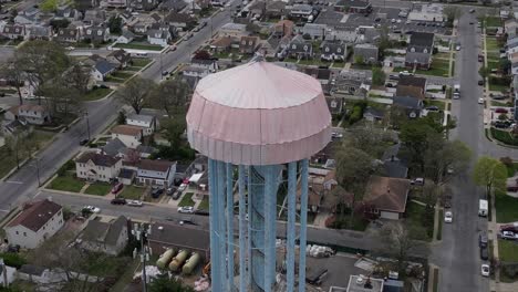 an aerial view of a water tower in elmont, new york under a tarp on a cloudy day