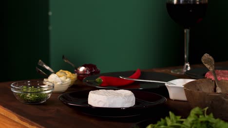 preparando una deliciosa comida con camembert, pimienta roja y vino