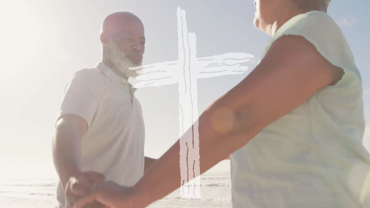 Holding hands at beach, elderly couple with white cross overlay animation