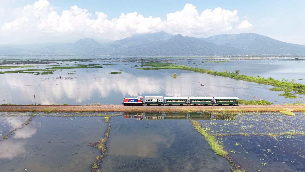 Una vista aerea del viaggio in treno d'epoca del Museo Ambarawa attraverso il lago Rawa Pening. Un viaggio nostalgico che utilizza una locomotiva diesel e carrozze classiche in legno.