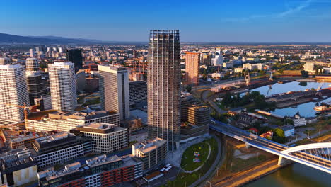 high-rises on the waterfront of the danube river. vast cityscape of modern part of bratislava, slovakia at sunset time. aerial view