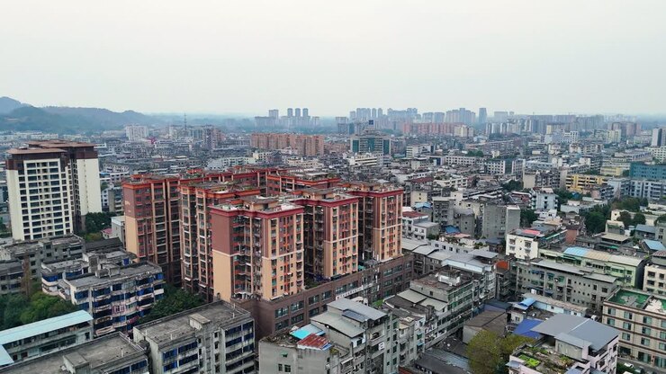 Aerial view of Chengdu's Xinjin County showcases a dense urban cityscape with residential buildings, bustling streets, and surrounding urban development.