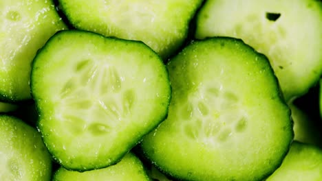 sliced pieces of green cucumber stacked on a hill rotate. fresh sliced cucumber pieces are rotating