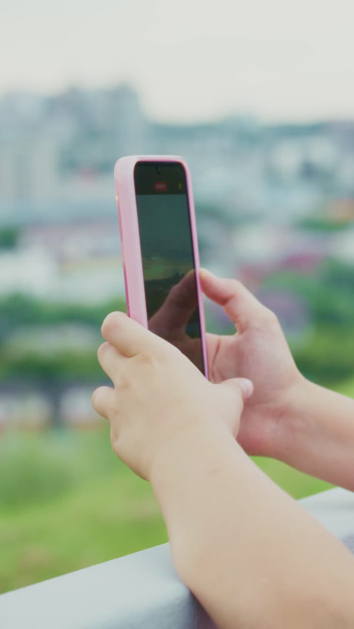 Capturing Moments: A Close-Up of a Hand Holding a Smartphone Against a Beautiful City Background, Highlighting the Joy of Mobile Photography