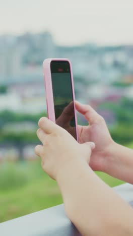capturing moments: a close-up of a hand holding a smartphone against a beautiful city background, highlighting the joy of mobile photography