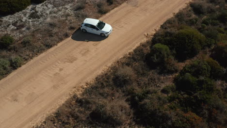 Coche-Blanco-Maniobrando-En-Camino-De-Tierra-En-El-Parque-Nacional-De-La-Costa-Oeste,-Sudáfrica