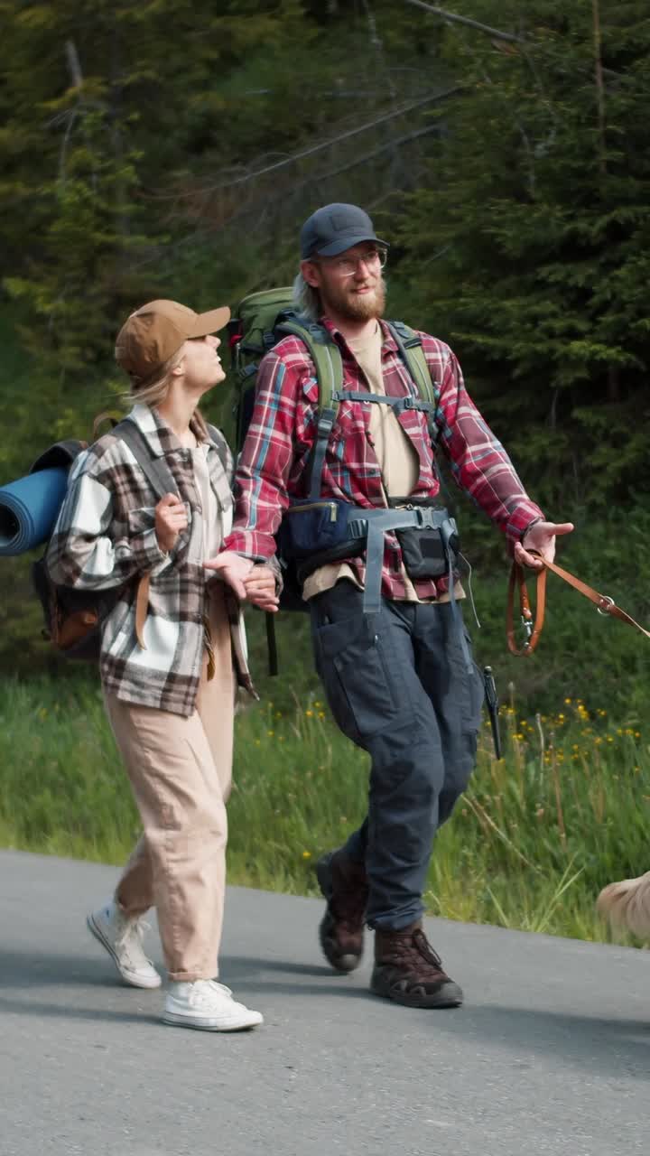Couple Hiking with Dog on Mountain Road