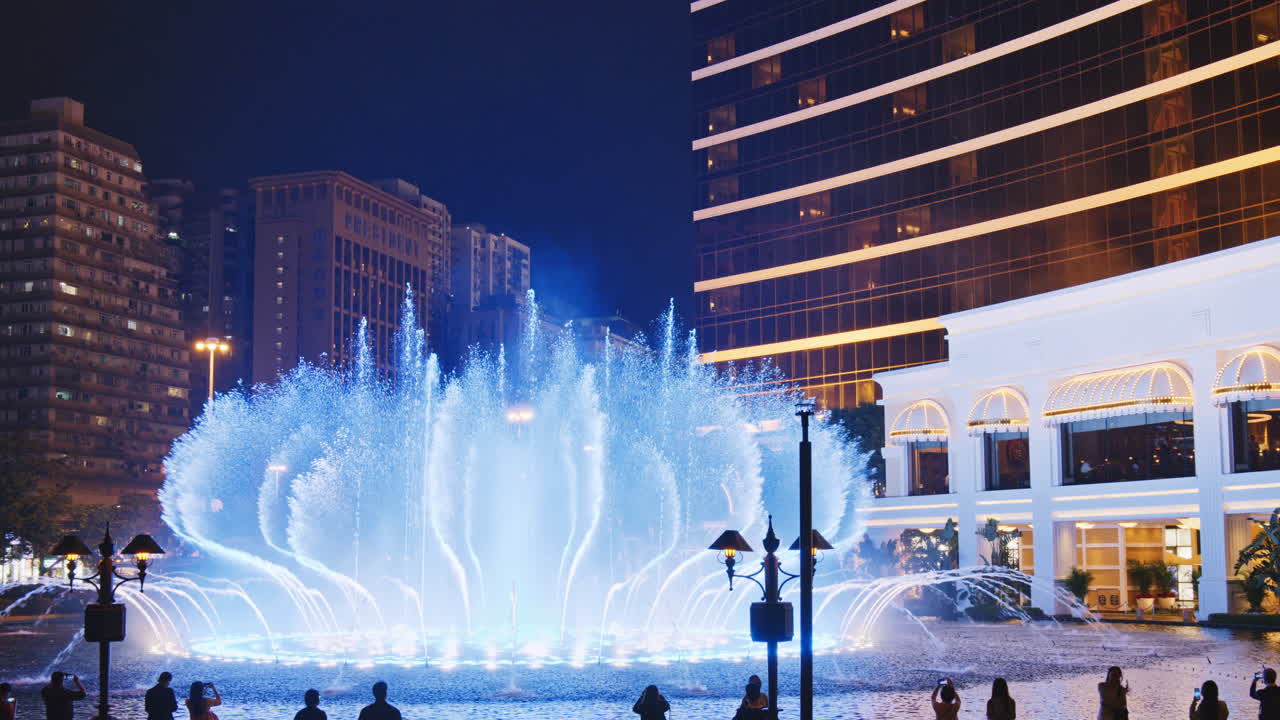 Espectacular espectáculo de fuentes iluminadas por la noche en una ciudad