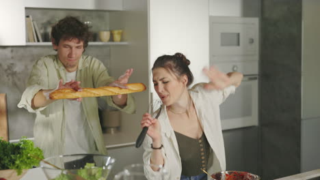 playful couple singing and cooking together in a modern kitchen