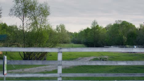 countryside view through a white wooden fence