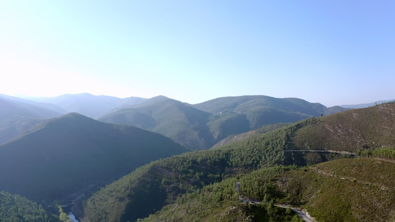 toma aérea de 4k volando lentamente una montaña rodeada de árboles y puesta de sol