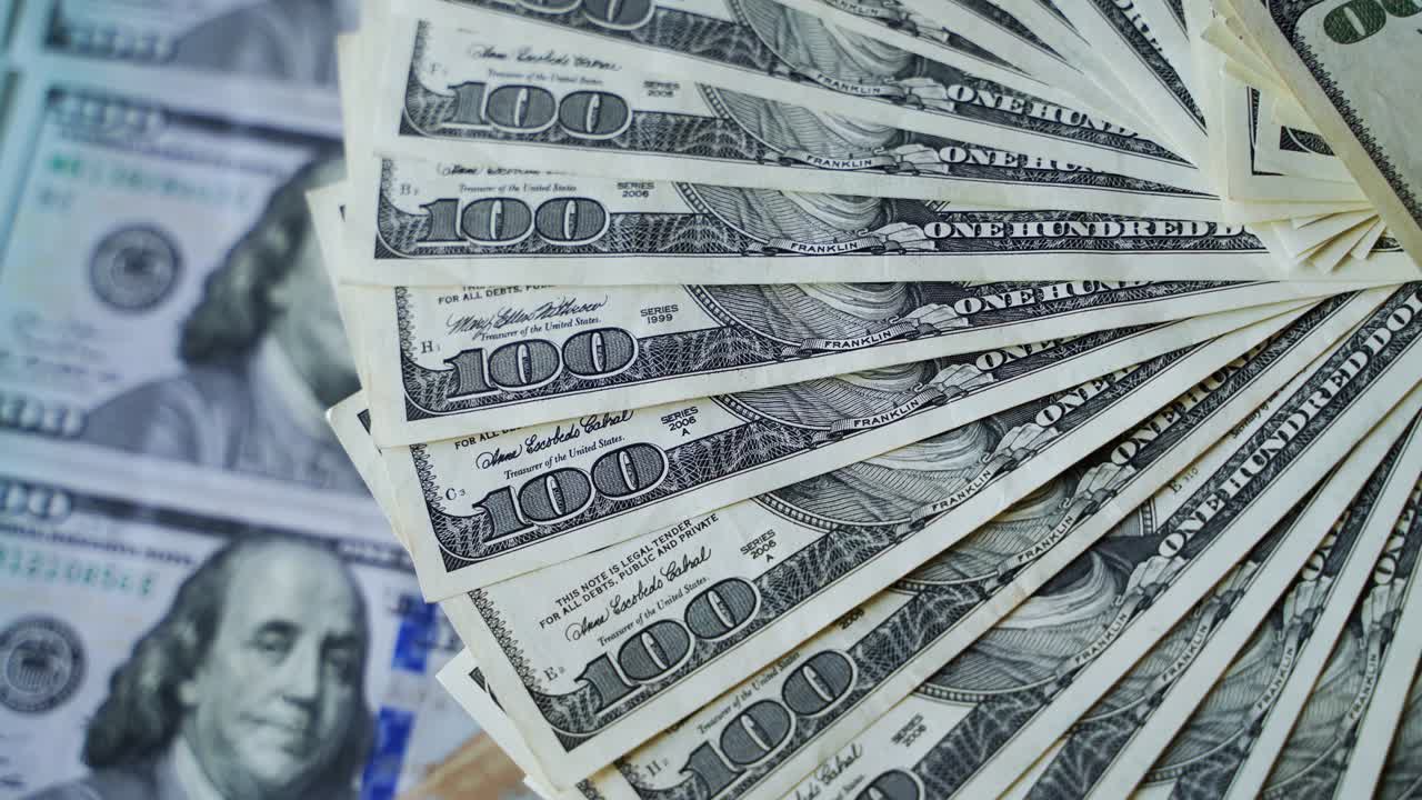 billetes de dólar descompuestos en un círculo. rotación de billetes de cien dólares. fondo del dinero estadounidense. primer plano.