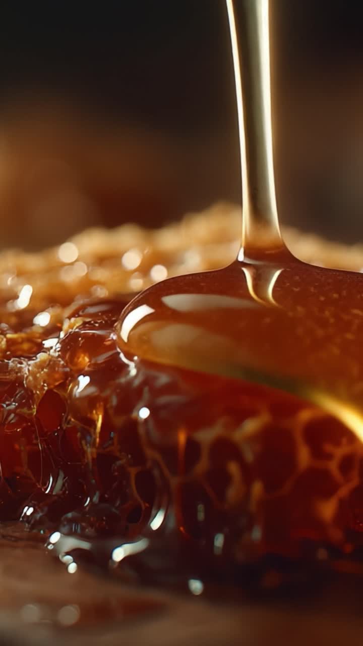 Primo piano accattivante di miele dorato che cola elegantemente su una superficie a nido d'ape, mostrando la sua ricca consistenza e la sua essenza deliziosamente dolce.