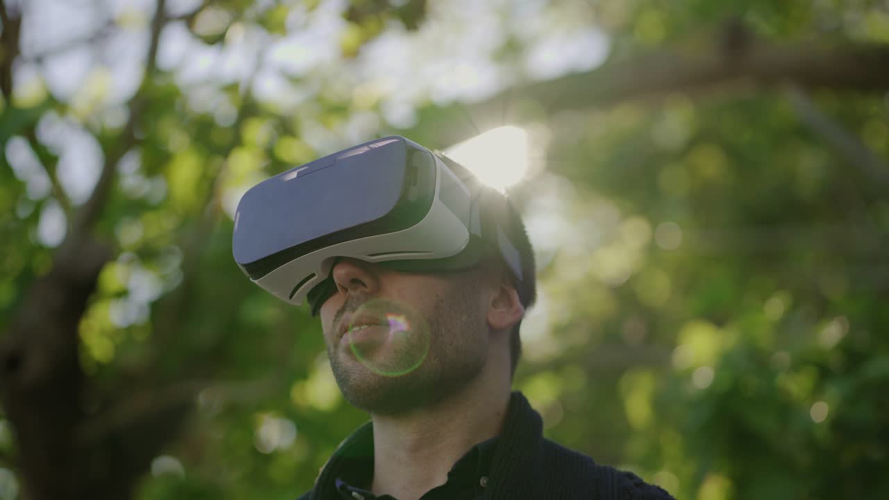 hombre sonriente usando auriculares de realidad virtual al aire libre