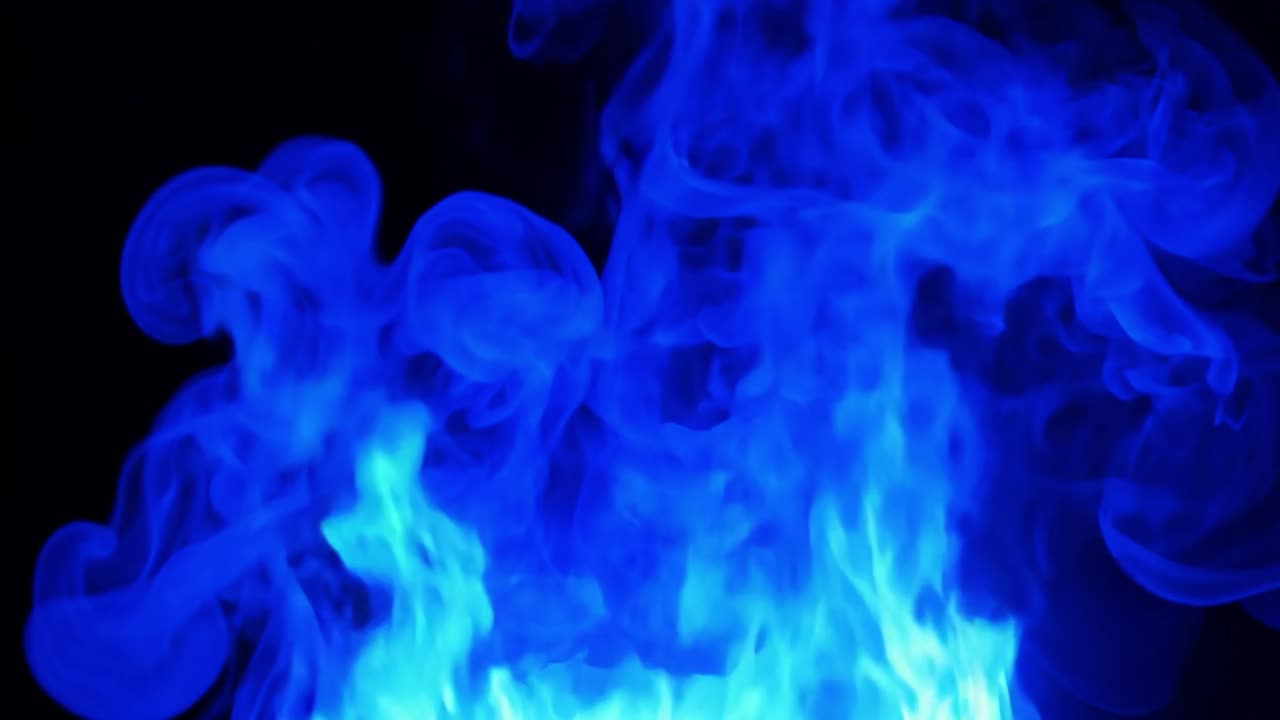 Bright blue flames rise against a stark black background, creating a striking visual of energy and heat. The dynamic motion captures the essence of fire's beauty and danger
