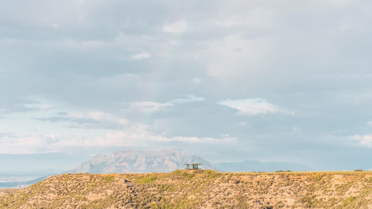 Colorful rainbow over rocky plateau with distant mountain view
