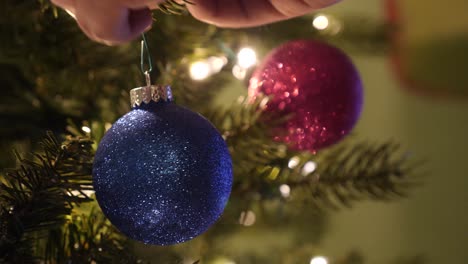 Primer-Plano-De-Una-Persona-Decorando-Un-árbol-De-Navidad-Con-Adornos-Brillantes