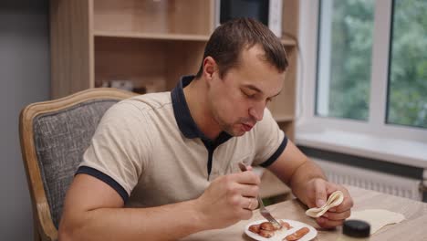 man eating sausages in a sandwich
