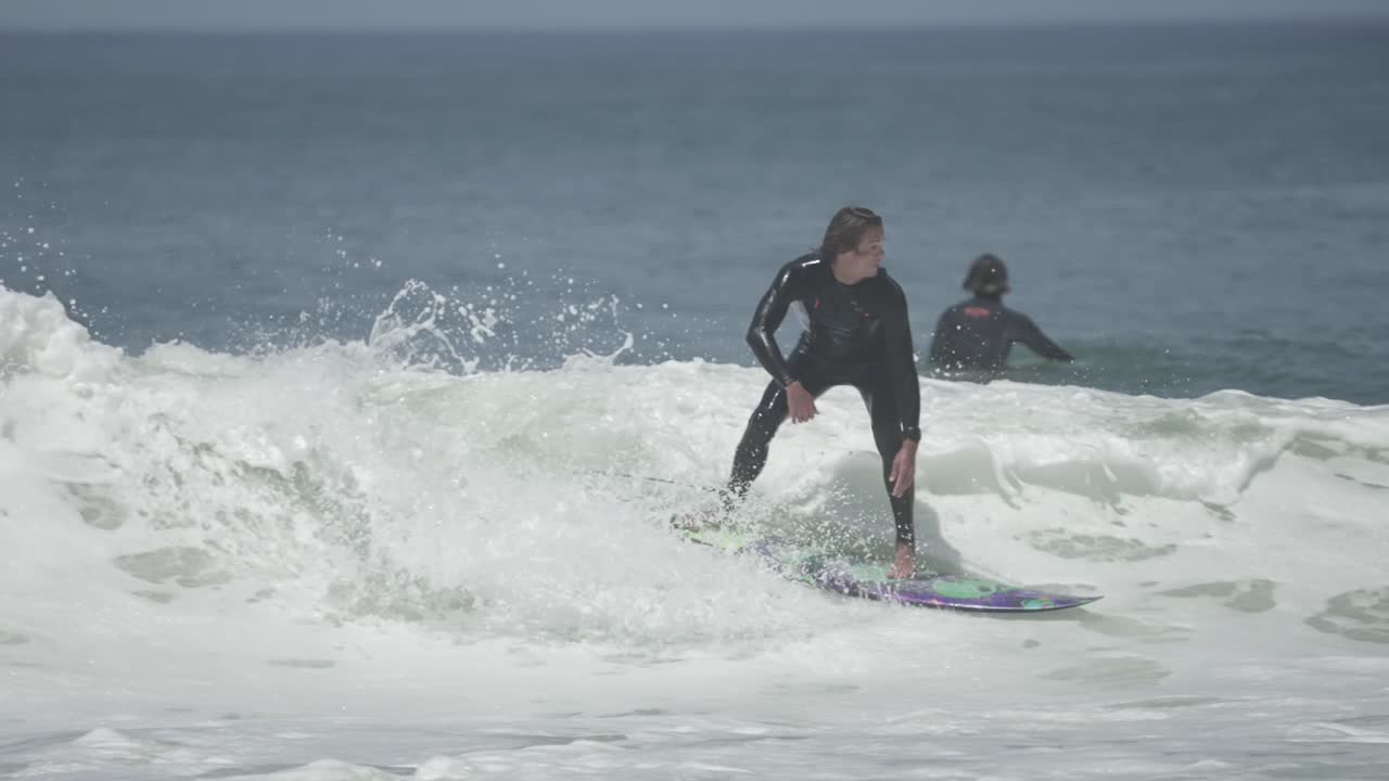 Full-speed air reverse above a crumbling lip. The surfer launches high with control, style and tension in the leash mid-rotation, mid-flight, pure surf progression