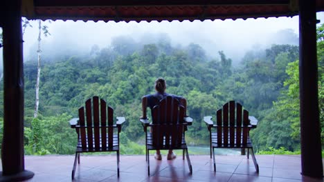man takes pictures on costa rica cloud rainforest resort lodge balcony