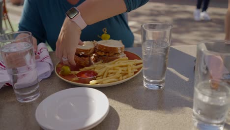 caucasian woman picking up a sandwich