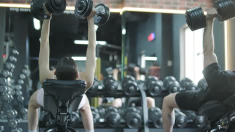 people exercising with dumbbells in a gym
