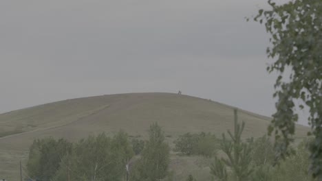 gente en la cima de una colina en un día nublado