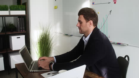 Male-teacher-sitting-at-desk